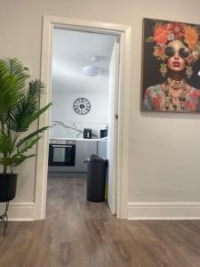 a doorway to a kitchen with a painting of a black woman at Bank Square - 1 Bedroom Apartment in Southport