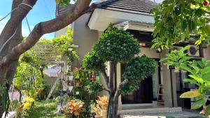 une maison avec des arbres devant elle dans l'établissement Moona Homestay Jogja, à Gondowulung