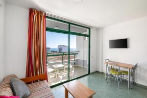 a living room with a couch and a table at RT-Green Park in Playa del Ingles