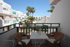 a balcony with a table and chairs and a view of the beach at Casa Linda in Costa Teguise