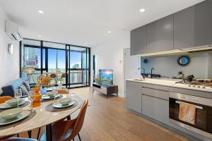 メルボルンにあるElegant High Rise 2 Bed Apt near Melb CBD RMITのキッチン、ダイニングルーム(テーブル付)、キッチン、ダイニングルームが備わります。