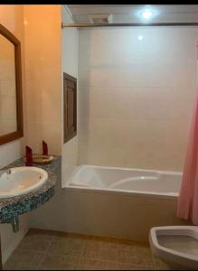 a bathroom with a tub and a sink and a toilet at UCS GUESt HOUSE in Siem Reap