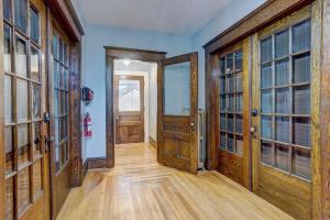 an empty hallway with wooden doors and wooden floors at The Kinley House in Lunenburg