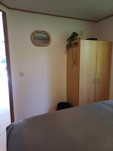a bedroom with a bed and a wooden cabinet at Camping Alkenhaer Appelscha Chalet 041 in Appelscha
