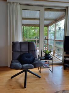 a chair in a living room with a large window at Camping Alkenhaer Appelscha Chalet 041 in Appelscha