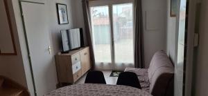 a living room with a couch and a tv at Domaine in Saint-Hilaire-de-Riez