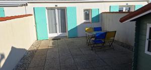 a patio with chairs and a table in front of a building at Domaine in Saint-Hilaire-de-Riez