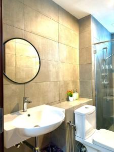 a bathroom with a sink and a mirror and a toilet at K avenue Studio by TZhomestay in Donggongon