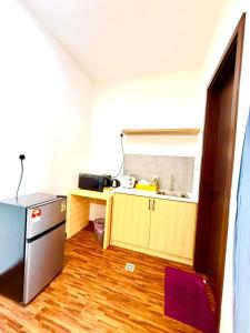 a small kitchen with a sink and a refrigerator at K avenue Studio by TZhomestay in Donggongon