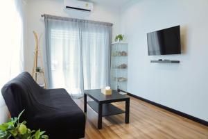 a living room with a black couch and a table at Ralf House in Hua Hin