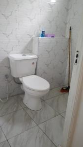 une salle de bain avec des toilettes blanches et un lavabo dans l'établissement Mazuri Homes,Ujamaa Building, à Gatunga