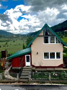 a red and white house with a green roof at Guest House Red Rock in Žabljak +38 photos