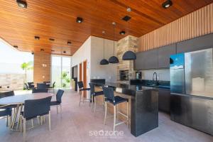 a kitchen with a dining area with tables and chairs at Apartamentos em Condomínio com Piscina e Academia - AGA in Camaçari