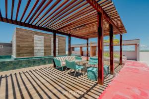 a wooden deck with chairs and a table at Apartamentos em Condomínio com Piscina e Academia - AGA in Camaçari