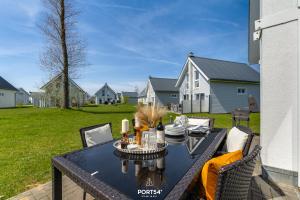 un patio avec une table et des chaises dans une cour dans l'établissement Ferienhaus Hygge Hus Olpenitz, à Olpenitz