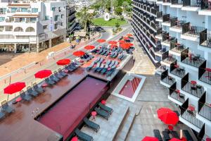 widok na basen ze stołami i parasolami w obiekcie Hotel Vibra District - Adults Only w mieście San Antonio