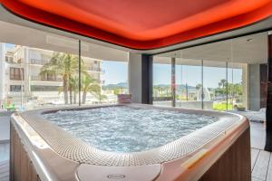 duża wanna z hydromasażem w pokoju z oknami w obiekcie Hotel Vibra District - Adults Only w mieście San Antonio