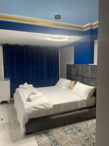 een groot wit bed in een kamer met een blauwe muur bij Appartement vue Mer Tanger Boulevard in Tanger