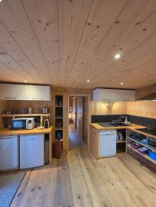 a large kitchen with wooden floors and a wooden ceiling at Appartement au rez de jardin d'une villa Mexicaine in Barcelonnette +7 photos