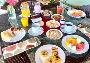 a table topped with plates of breakfast foods and drinks at Pousada Chantilly in São Miguel do Gostoso