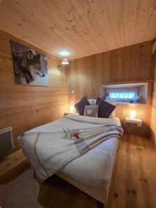 a bedroom with a large bed in a wooden wall at Appartement au rez de jardin d'une villa Mexicaine in Barcelonnette
