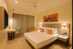 a hotel room with a bed and a desk at Lemon Tree Hotel, Chinchwad, Pune in Pune