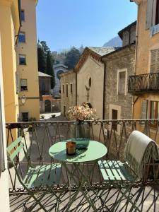 a table and two chairs on a balcony at Palazzo Gamba Denti Apartment in Bellano