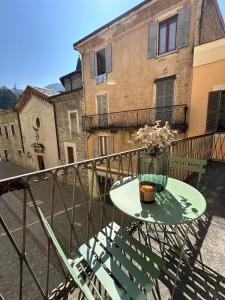 a table on a balcony with a vase of flowers at Palazzo Gamba Denti Apartment in Bellano