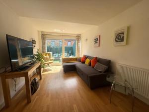 Una sala de estar con un sofá y un televisor de pantalla plana. en Welcome Guests City Centre Apartment, en Chester