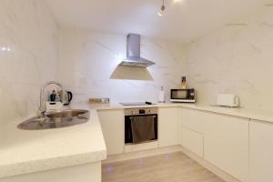 Una cocina blanca con fregadero y microondas. en Welcome Guests City Centre Apartment, en Chester 9 fotos más