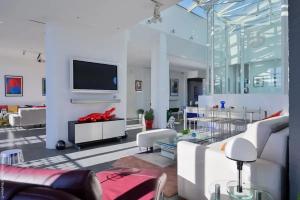 a living room with white furniture and a flat screen tv at Appartement d'architecte de 260m² avec grand balcon à Marseille in Marseille
