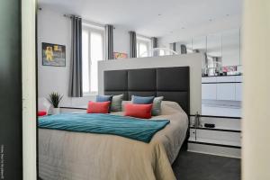 a bedroom with a large bed with red and blue pillows at Appartement d'architecte de 260m² avec grand balcon à Marseille in Marseille