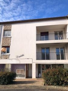 un bâtiment blanc avec des balcons sur le côté dans l'établissement Bienvenue à l'Oustalet Appt 5, à Cazaubon