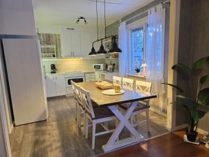 a kitchen with a table and chairs and a refrigerator at Villa Hugo in Vidsel