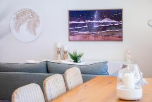ヌーサヘッズにあるEndless Summer Beach Retreat-pet friendly, walk to shopsのソファとテーブルと椅子のあるリビングルーム