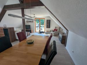 a dining room and living room with a wooden table at Ferienwohnung Rheinwald in Hartheim