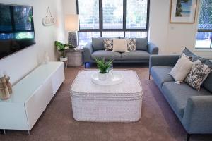 ヌーサヘッズにあるEndless Summer Beach Retreat-pet friendly, walk to shopsのソファ2つとコーヒーテーブルのあるリビングルーム