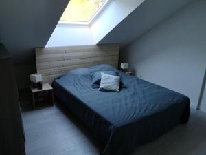 ein Schlafzimmer mit einem Bett mit Kissen und einem Fenster in der Unterkunft Gite du Gehan #Vosges #Ski #Nature in Cornimont