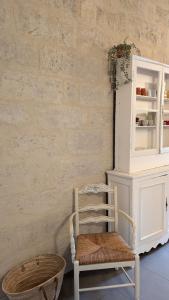 a chair in a room with a white cabinet at Appartement de charme au coeur d'Uzès in Uzès