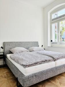 Una cama en una habitación blanca con ventana. en Villa Maria # 1, en Bad Oeynhausen