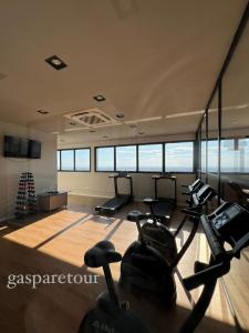 a gym with cardio machines in a room with windows at Gasparetour Flat - em frente ao Shopping Estação in Cuiabá