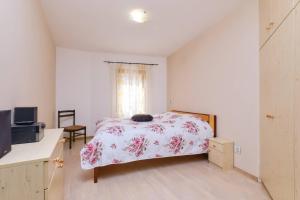 a bedroom with a bed and a television and a window at Apartment Dino 1 in Mali Lošinj