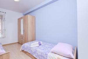 a bedroom with a bed and a wooden cabinet at Apartment Dino 1 in Mali Lošinj