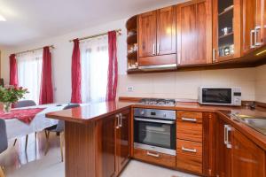a kitchen with wooden cabinets and a stove top oven at Apartment Dino 1 in Mali Lošinj +16 photos