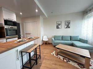 a living room with a blue couch and a table at La Suite Aurence, chic et calme in Panazol