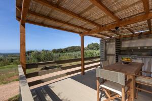 an outdoor dining area with a pergola and a table at Agriturismo Glamping L'Olivo Country Holidays in Campiglia Marittima