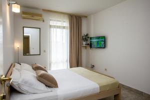 a bedroom with a bed with a mirror and a window at Apartments Ardura in Petrovac na Moru