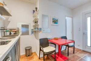 Villa - Oasis centre charme في مونبلييه: طاولة حمراء وكراسي في مطبخ