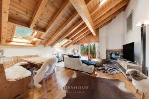 a living room with wooden ceilings and a table and chairs at Santa Fe l View l Duplex l By CosyHome in Crans-Montana