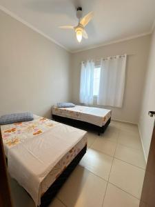 a bedroom with two beds and a ceiling fan at Casa Carvalho in Peruíbe +35 photos